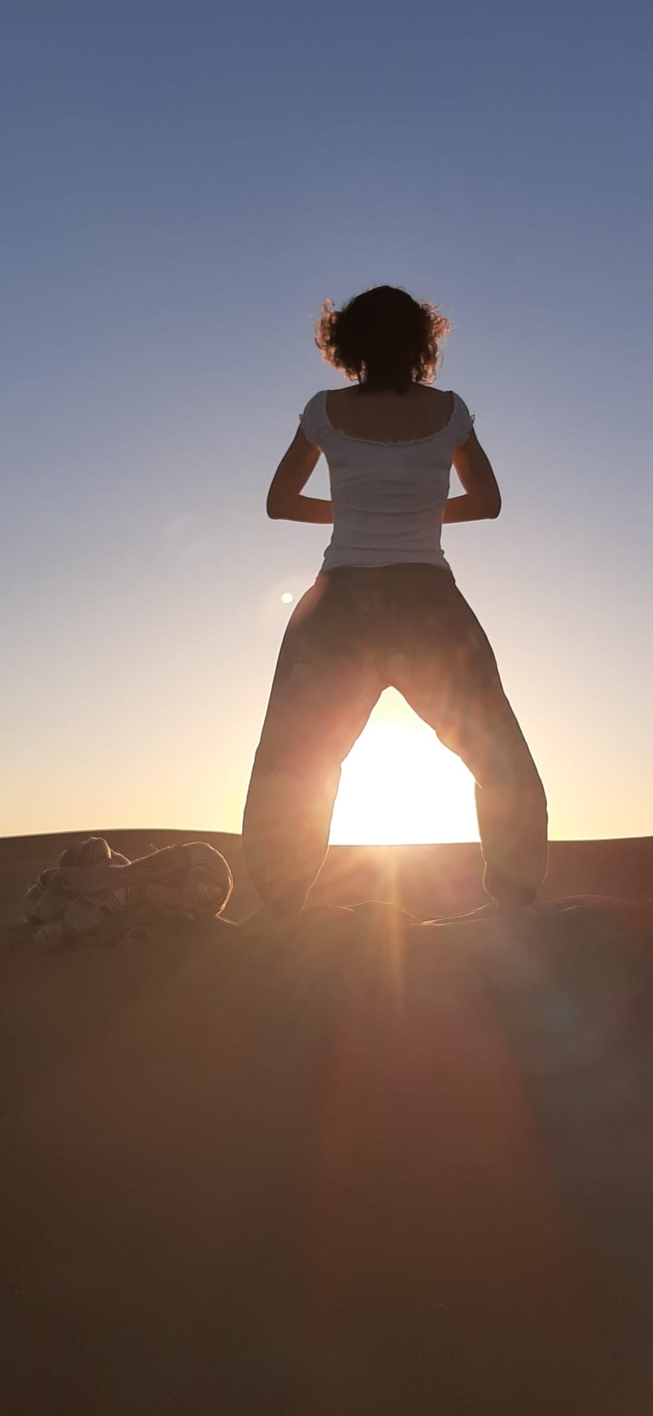 woman's standing meditates looking at the sun